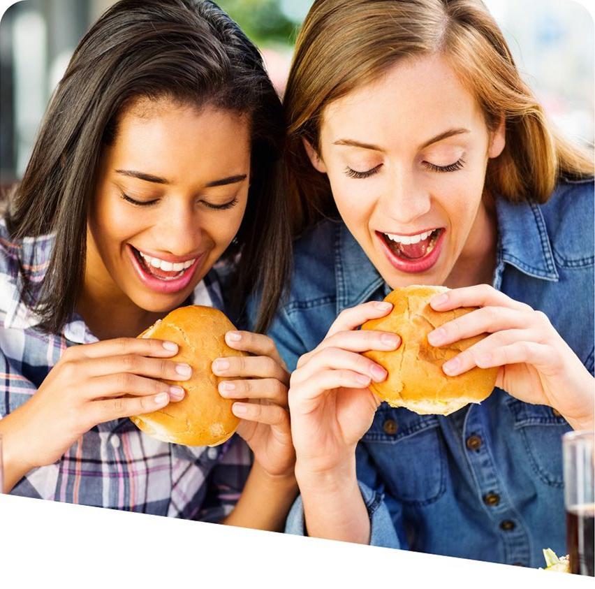 两个年轻女子正在享用用新鲜出炉的面包做的三明治.